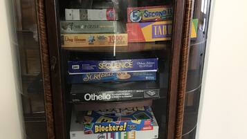 A wooden display case containing various board games and puzzles.