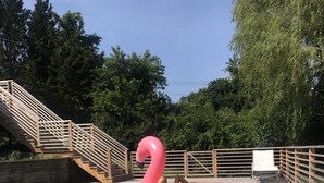 Une piscine avec un flotteur en forme de flamant rose et un ballon.
