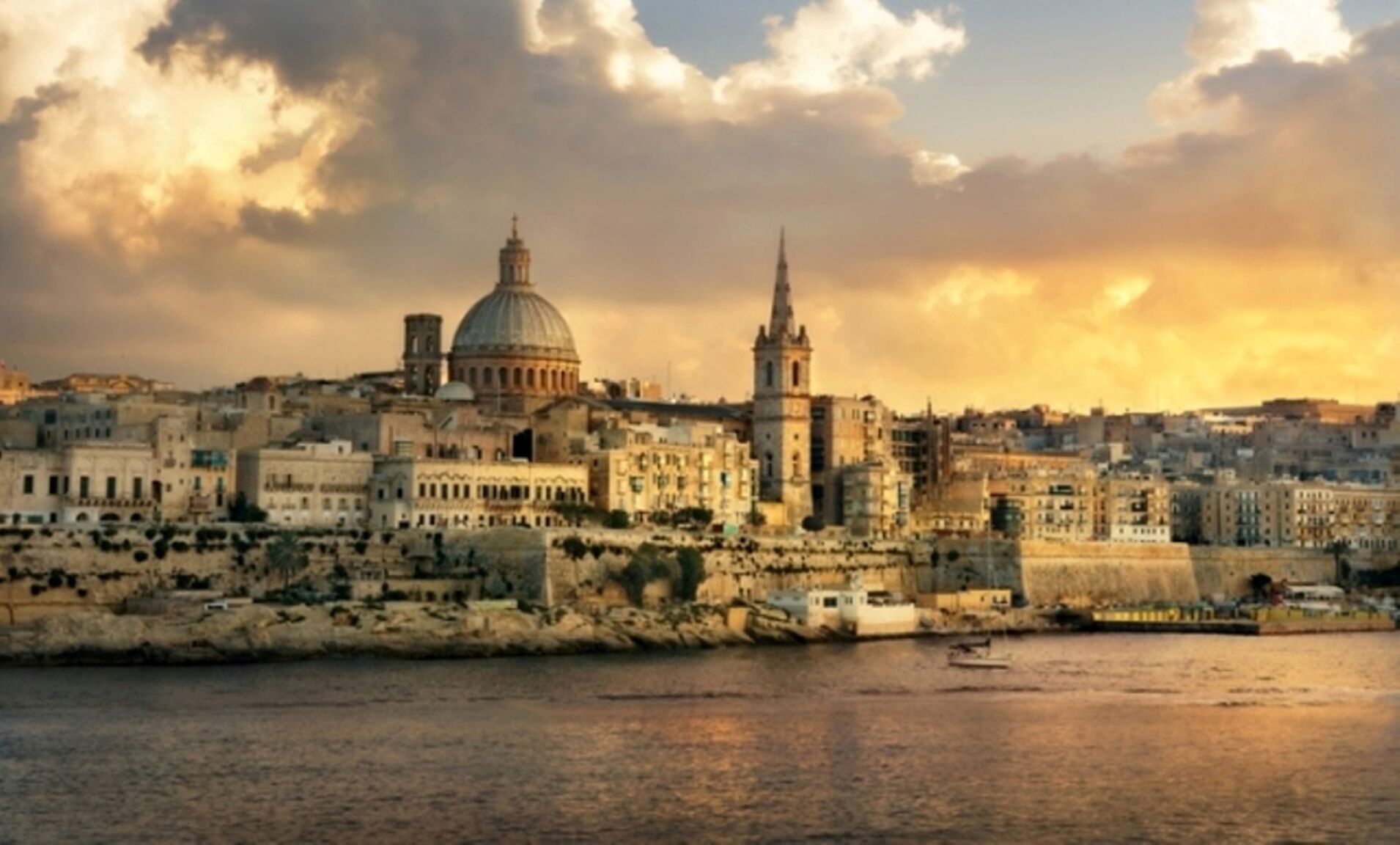 A historic cityscape with prominent architecture, including a dome and spires, along a waterfront.