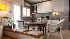 A modern kitchen with white cabinetry, a central island with stools, and a built-in oven.