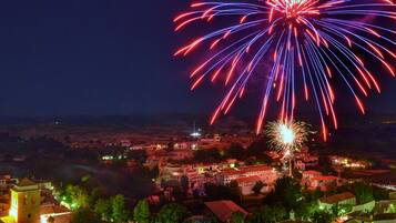 Un pueblo con una imponente torre de iglesia y una vista de fuegos artificiales en el cielo.
