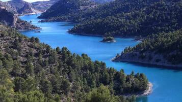 Un paisaje montañoso con un lago azul cristalino rodeado de bosques densos.