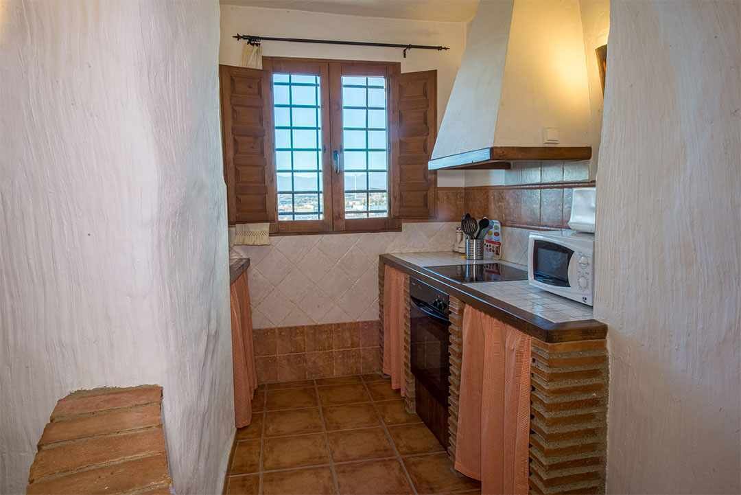 A compact kitchen with a window, a microwave, and a sink.