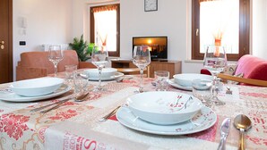 A dining area with a table set for four, including plates, glasses, and cutlery.