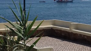 Vista sulla costa, con un lampione e barche a vela sull'acqua.