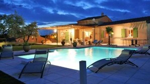 A poolside area with lounge chairs and a building with a tiled roof. - House / Villa - Visan (Visan)