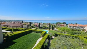 Un quartier résidentiel doté d’une piscine, entouré de jardins bien entretenus et de maisons aux toits recouverts de tuiles rouges.
