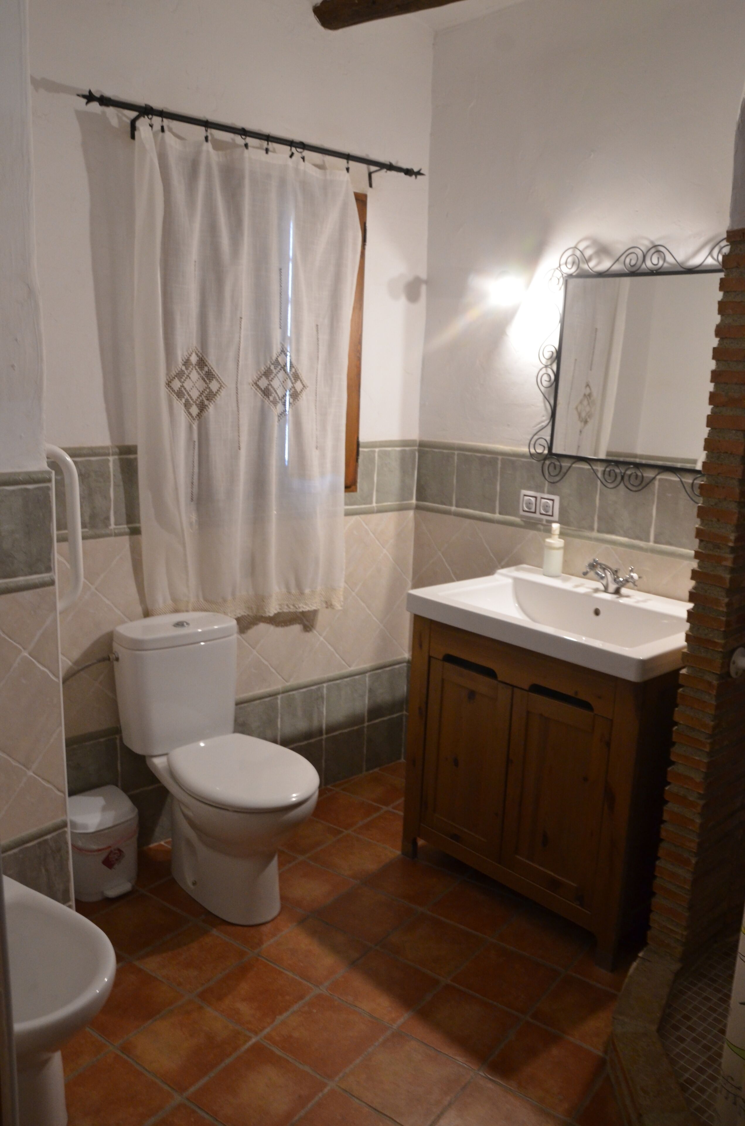Un bagno con servizi igienici, lavandino e tenda doccia.