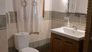 Un bagno con servizi igienici, lavandino e tenda doccia.