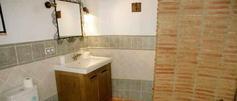 A bathroom with a wooden cabinet, a white sink, and a toilet.