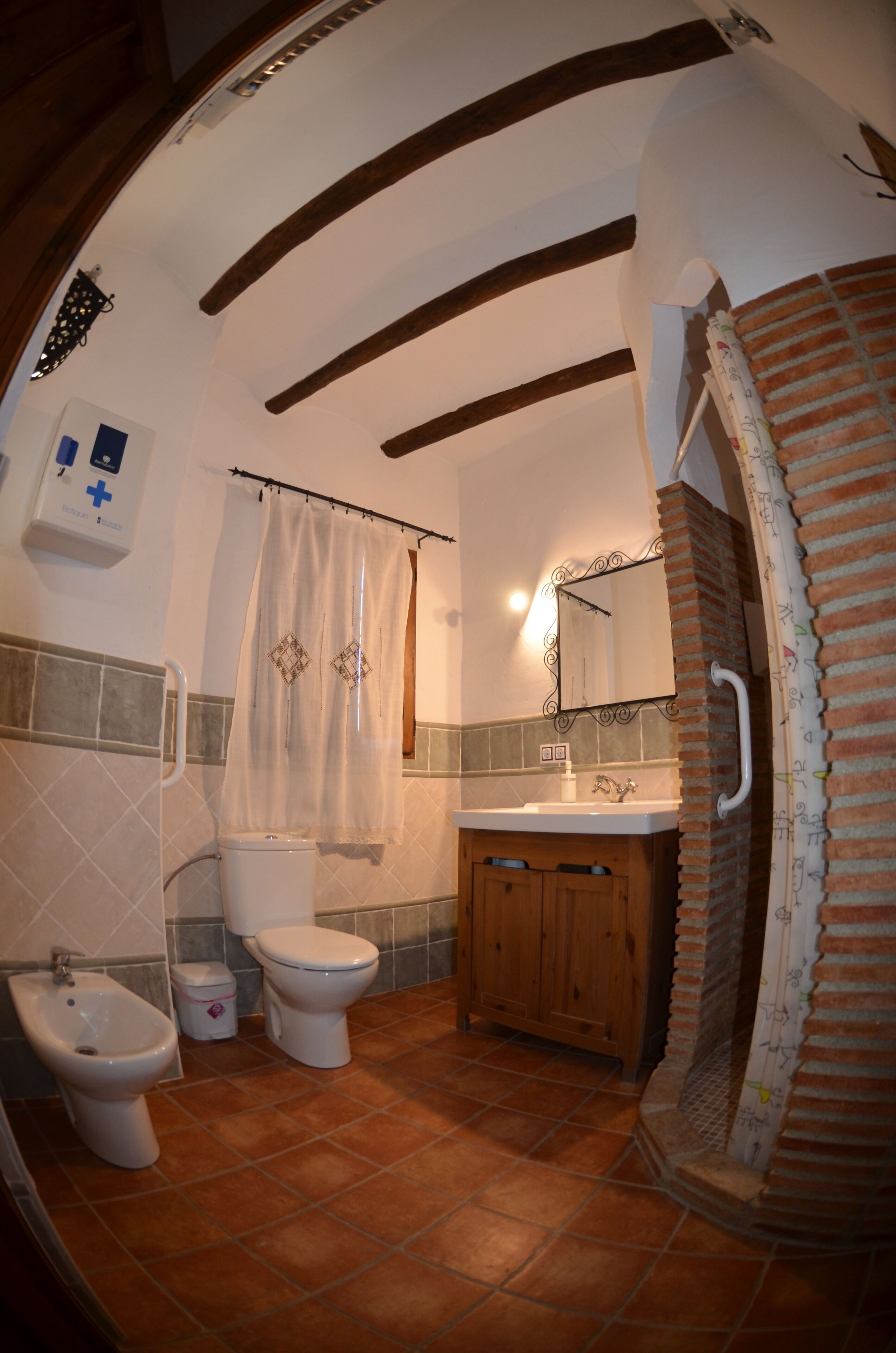 Une salle de bain équipée de toilettes, d’un bidet, d’un lavabo et d’un rideau de douche.