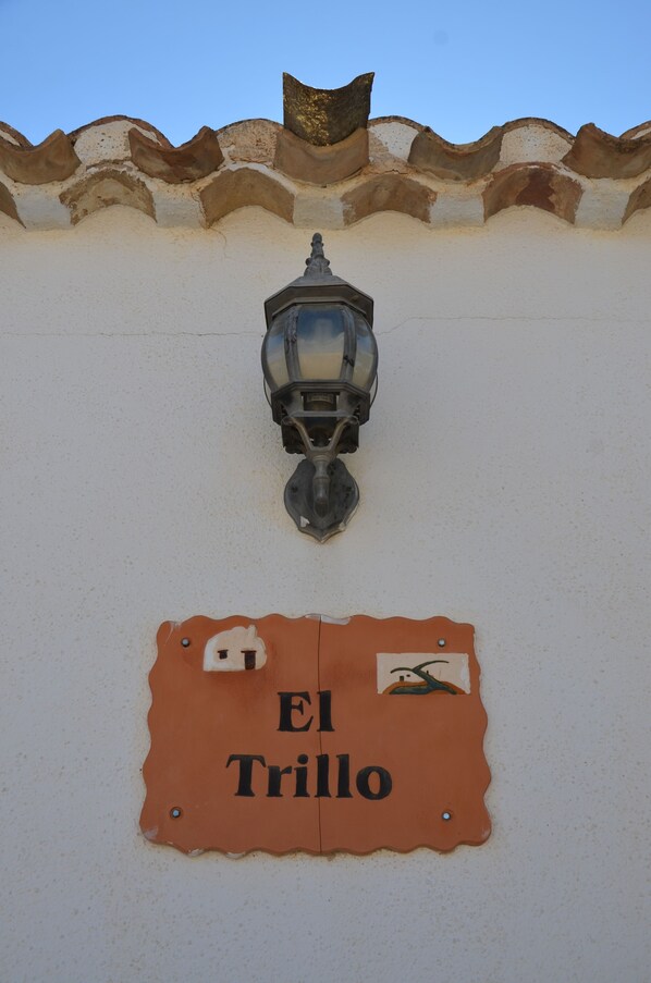 Une enseigne portant l’inscription « El Trillo » est fixée à un mur.