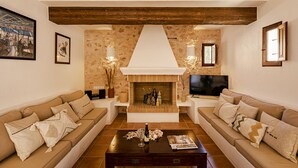 A living room with two sofas, a coffee table, a fireplace, and a television. - CAN NOVES - Villa 5 suites 9 & 31 (Sant Francesc de Formentera)