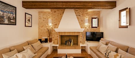 A living room with two sofas, a coffee table, a fireplace, and a television.