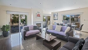 Amplia sala de estar con dos sofás, una mesa de centro y una chimenea.