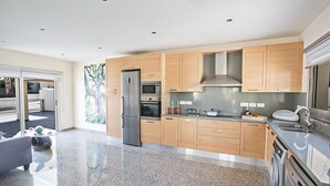Una cocina moderna con armarios de madera, electrodomésticos de acero inoxidable y encimera de granito.
