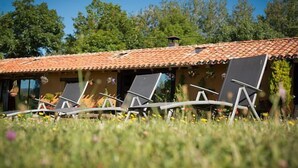 A building with a tiled roof and a row of lounge chairs in front. - Rural house (full rental) "Casucas La Guariza" for 6 people (Hermandad de Campoo de Suso)