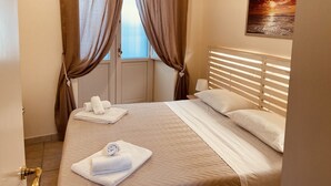A hotel room with a bed, curtains, a painting, and a window. - Dimora del Vico - Suite Elite (Lecce)