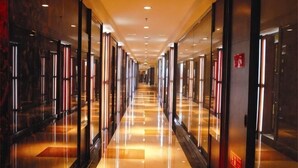 A long, well-lit hallway with reflective floors and glass doors on both sides. - Taitan International Hotel (Xinchang)