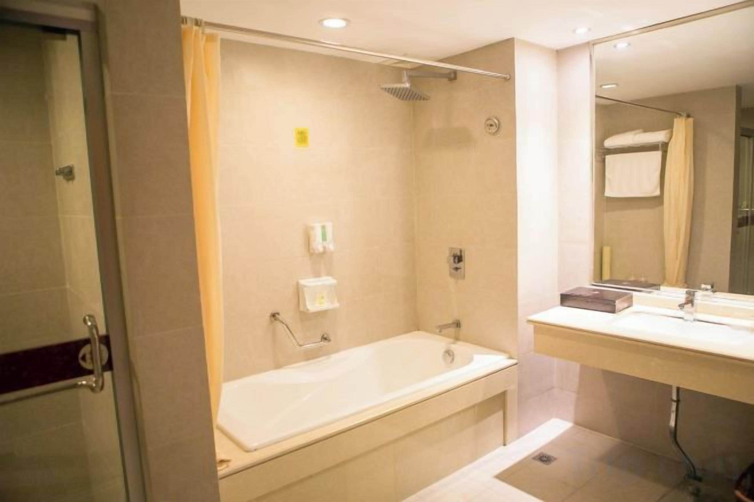 Ein Badezimmer mit Badewanne, Dusche, Waschbecken und Spiegel.