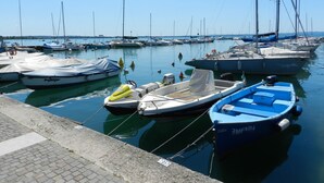 Un puerto deportivo con varias embarcaciones amarradas, incluyendo un pequeño barco azul con el número 3MEND4.