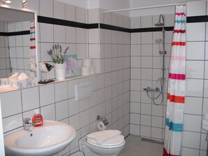 A bathroom with a sink, toilet, shower, and a mirror. - Apartment in the heart of Kreuzberg, loft,art,pubs,bars,nightlife,WiFi,up to 4 persons (Bezirk Friedrichshain-Kreuzberg)