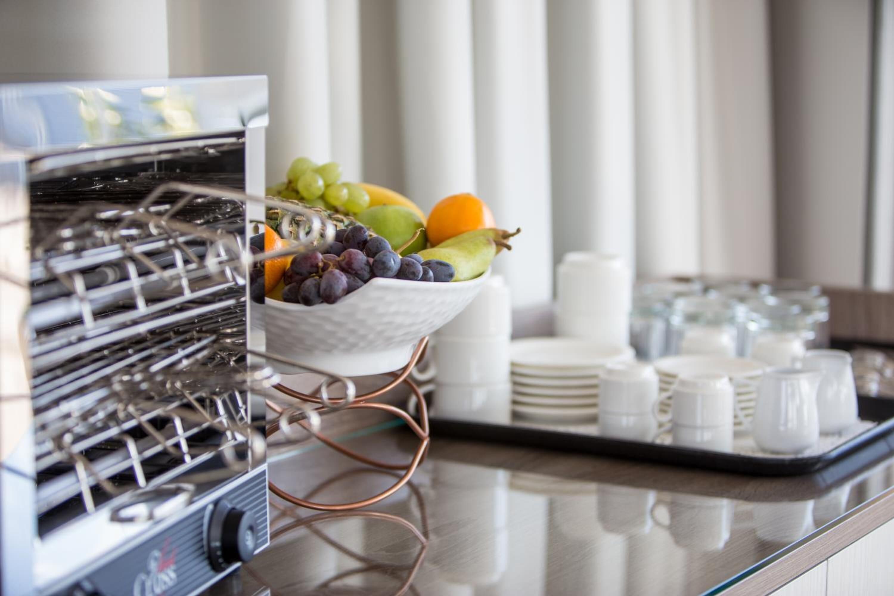 A breakfast buffet with a variety of fruits and a coffee machine.