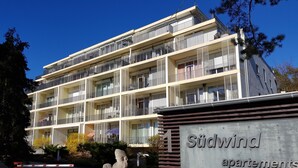 Ein mehrstöckiges Gebäude mit Balkonen, beschriftet mit "Südwind Apartments".