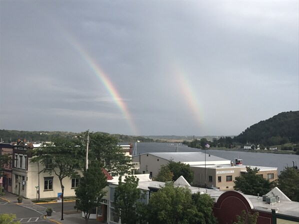 A town with buildings, a river, and a rainbow.