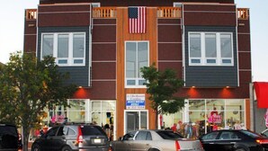 A two-story building with a sign for '2-3 Bedroom Condo'. - Downtown Condo With Lake & BAY Views (Frankfort)