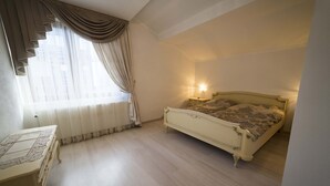 A bedroom with a bed, a bedside table, and a window with curtains. - Cozy house near the gondola in Bansko.  (Bansko)