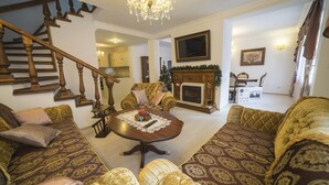 A living room with a staircase, a fireplace, and a Christmas tree. - Cozy house near the gondola in Bansko.  (Bansko)