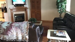 A living room with a fireplace, a television, a couch, and a coffee table. - Family Friendly Lake House Located at Mid-west arm of Lake Fork (Quitman)