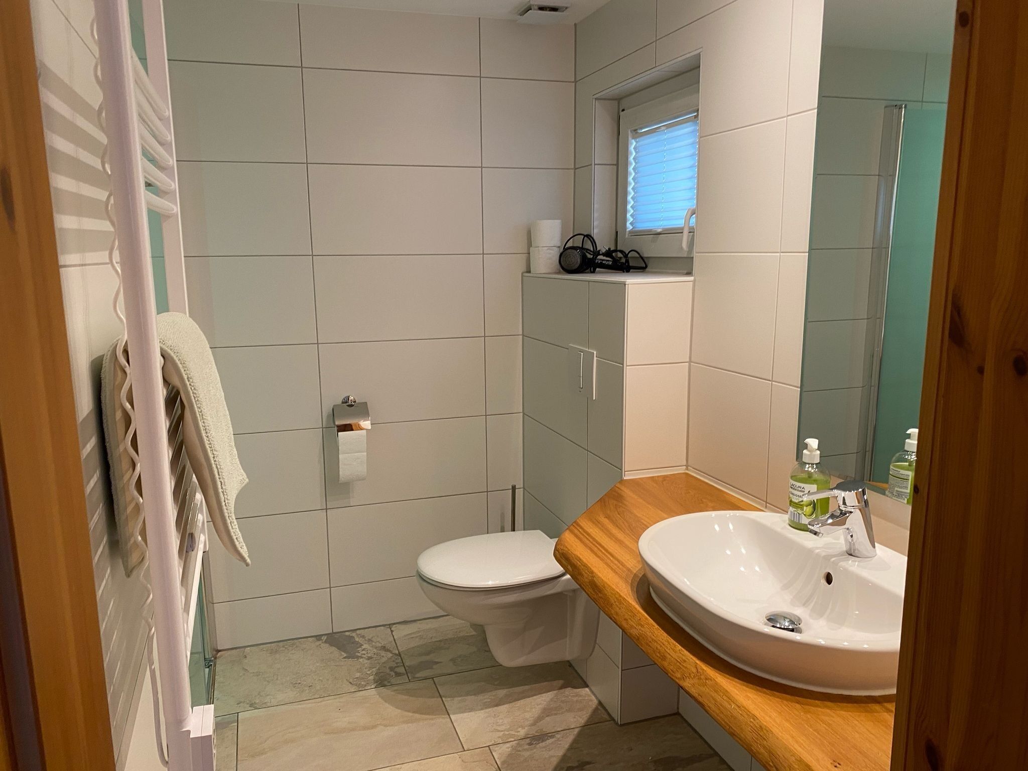 Een moderne badkamer met toilet, wastafel en douche.