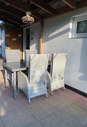 A patio with wicker furniture, a glass table, and a ceiling fan. - Feel-good oasis "Willi" - vacation with dog (Harzgerode)