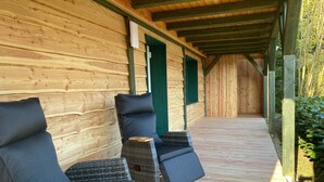 A covered outdoor seating area with wicker furniture and a wooden floor. - Feel-good oasis "Willi" - vacation with dog (Harzgerode)