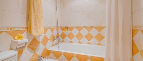 A bathroom with a bathtub, a toilet, and a shower.