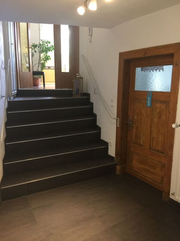 A staircase leading to a wooden door with a frosted glass panel.
