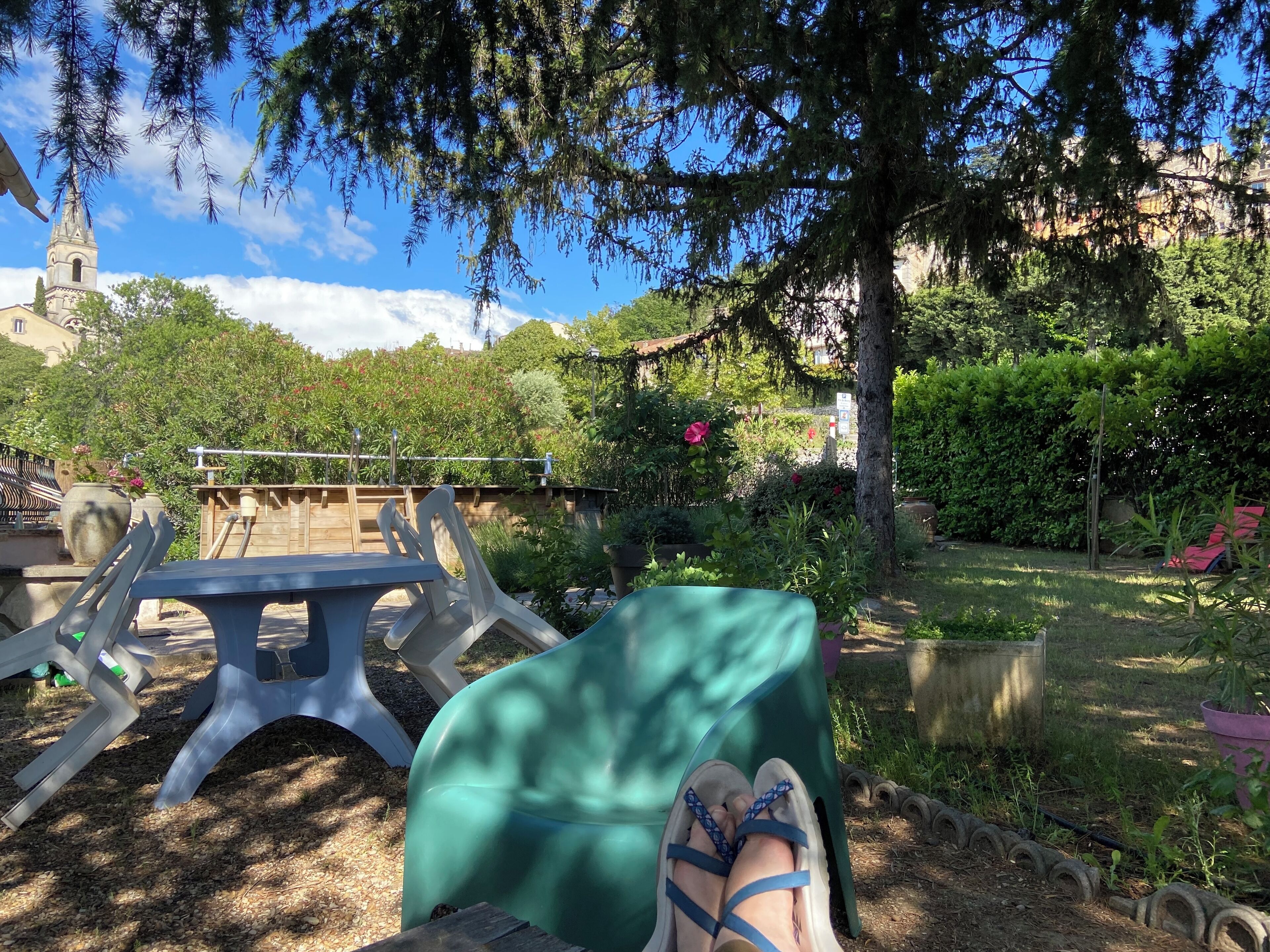 Un jardin avec une table et des chaises, un banc et un arbre.