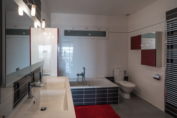 Une salle de bain moderne avec un grand lavabo, une baignoire et des toilettes.