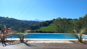 A clear blue sky, a swimming pool, and a hilly landscape in the background. - Former sheepfold renovated with beautiful view of the Pyrenees ideal for the family (Astugue)
