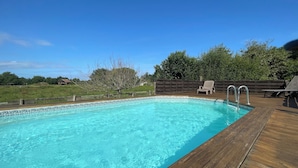 A rectangular swimming pool with clear blue water, surrounded by a wooden deck. - Peaceful haven with swimming pool near the port and beach (Audenge)