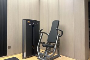Eine Ecke eines Raumes mit einem schwarzen Trainingsgerät und einer Holzverkleidung.
