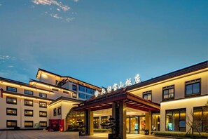 A hotel with a modern architectural design, featuring a prominent entrance with a covered walkway and a large sign above the entrance. - Ningbo Nanyuan Zhaobaoshan Hotel (Ningbo)