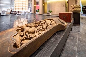A detailed wooden carving on a reception desk in a hotel lobby. - Ningbo Nanyuan Zhaobaoshan Hotel (Ningbo)