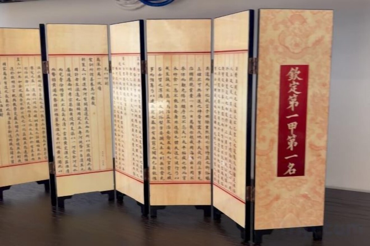 A traditional Japanese room with tatami flooring and a sliding door with calligraphy.