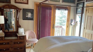 A bedroom with a large bed, a wooden dresser, a mirror, and framed pictures on the wall. -  Ski History Unit with 2 decks, sleeps 2- walk to Base area for concerts (Mt Crested Butte)