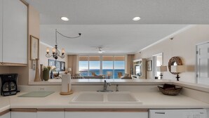 Cozinha moderna com uma janela ampla, um candelabro e vista para o oceano.