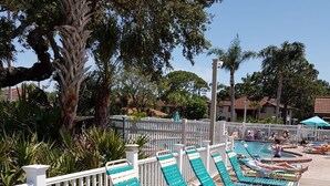 Un espace aménagé au bord de la piscine, avec plusieurs chaises longues et une piscine.