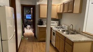 A kitchen with wooden cabinets, a gas stove, a microwave, and a sink. - Waterfront Plymouth Pond Retreat, Sleeps 6, Pet-Friendly, Kayaks, Fire Pits (Plymouth)